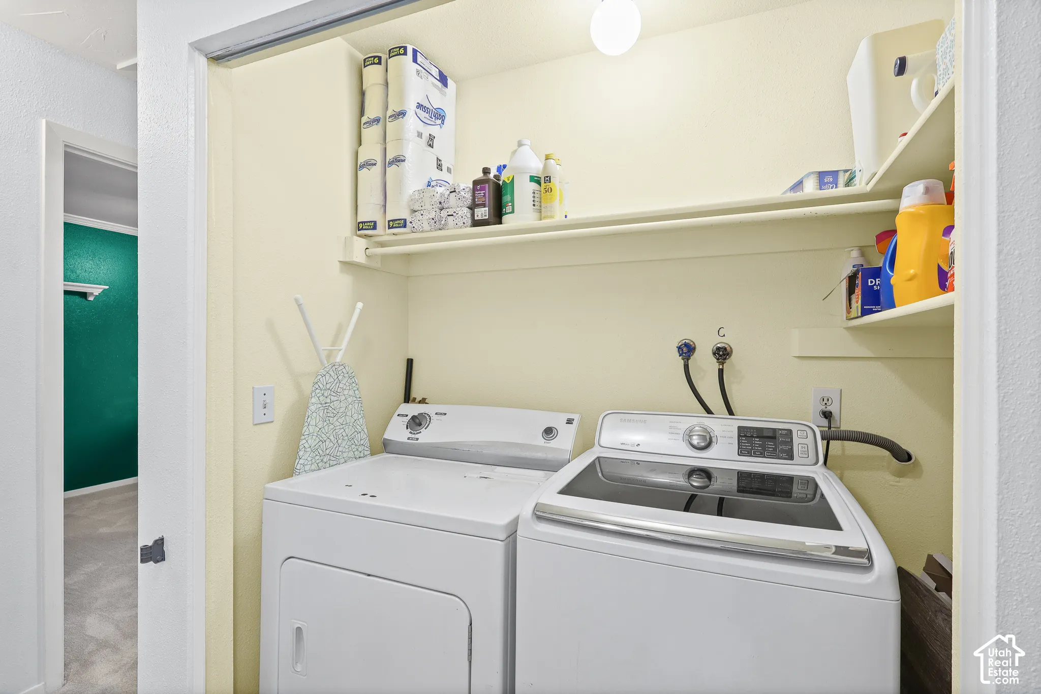Laundry closet featuring built-in shelving, overhead lighting, and dedicated water and electrical hookups