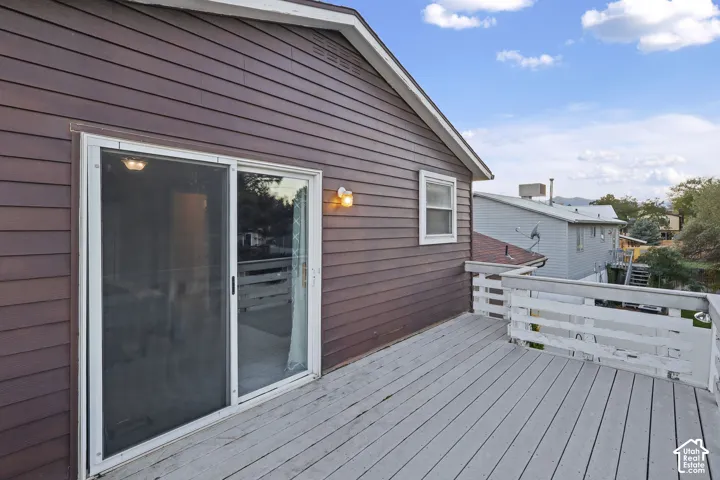 Main bedroom private balcony with horizontal railing, horizontal lap siding, and sliding glass door