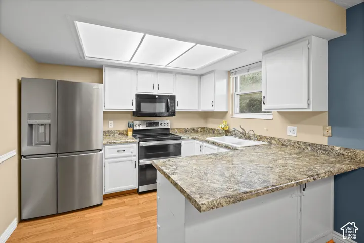Kitchen featuring white cabinetry, stone-patterned laminate countertops, stainless steel appliances, recessed ceiling lighting, and wood-finish flooring