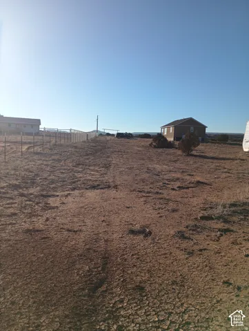 Expansive desert acreage featuring wire fencing and native vegetation