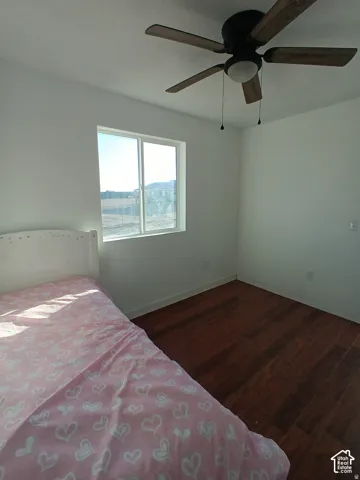 Wood-finish flooring, ceiling fan with integrated lighting, and dual-pane sliding window