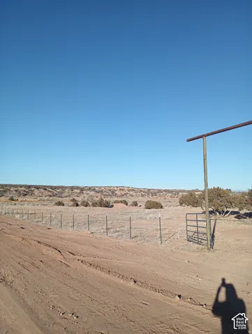 Expansive acreage featuring wire perimeter fencing and a metal gate entrance
