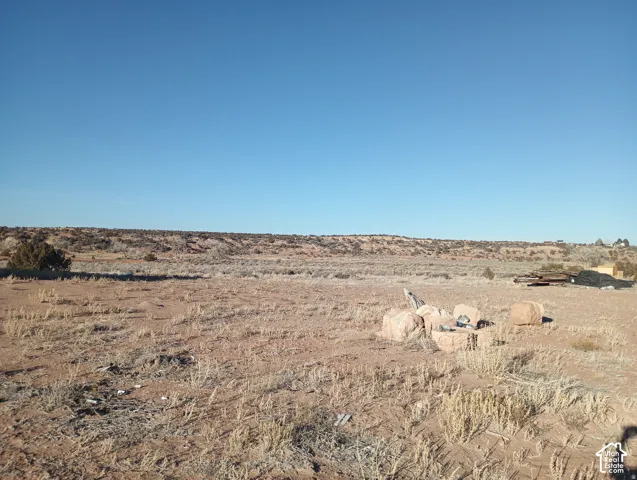 Expansive desert landscape featuring native vegetation and natural stone outcroppings under a clear sky