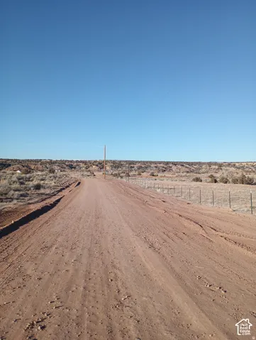 Expansive unimproved acreage featuring natural desert terrain, native vegetation, and wire perimeter fencing
