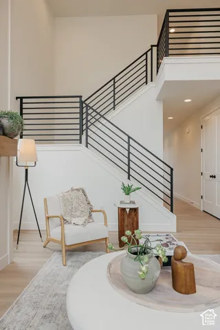 Staircase featuring horizontal matte black metal railings, wood-finish flooring, and recessed ceiling lighting