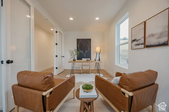 Room featuring wood-finish flooring, recessed lighting, and double glass-paneled doors with matte black hardware