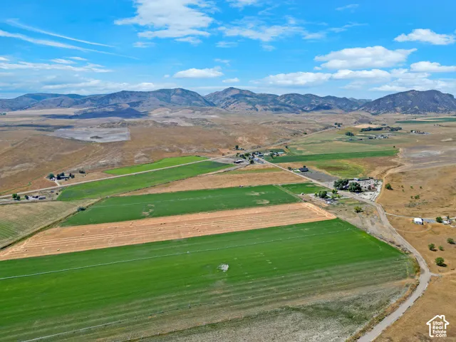 Aerial landscape featuring expansive agricultural acreage, cultivated fields, and prominent mountain backdrops