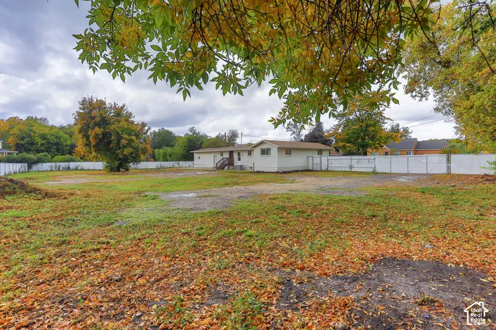 Expansive lot featuring a white privacy fence and mature trees