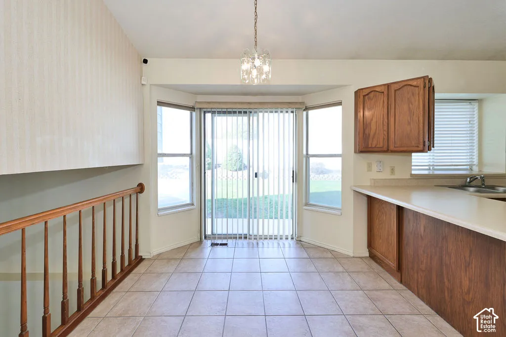 Vaulted ceiling, ceramic tile flooring, bay window, sliding glass door, and wooden balustrade