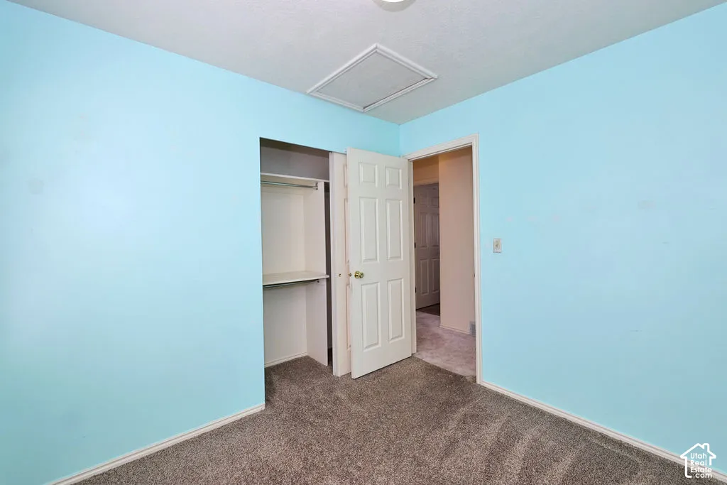 Carpeted flooring, built-in closet with shelving and hanging rod, and six-panel interior door