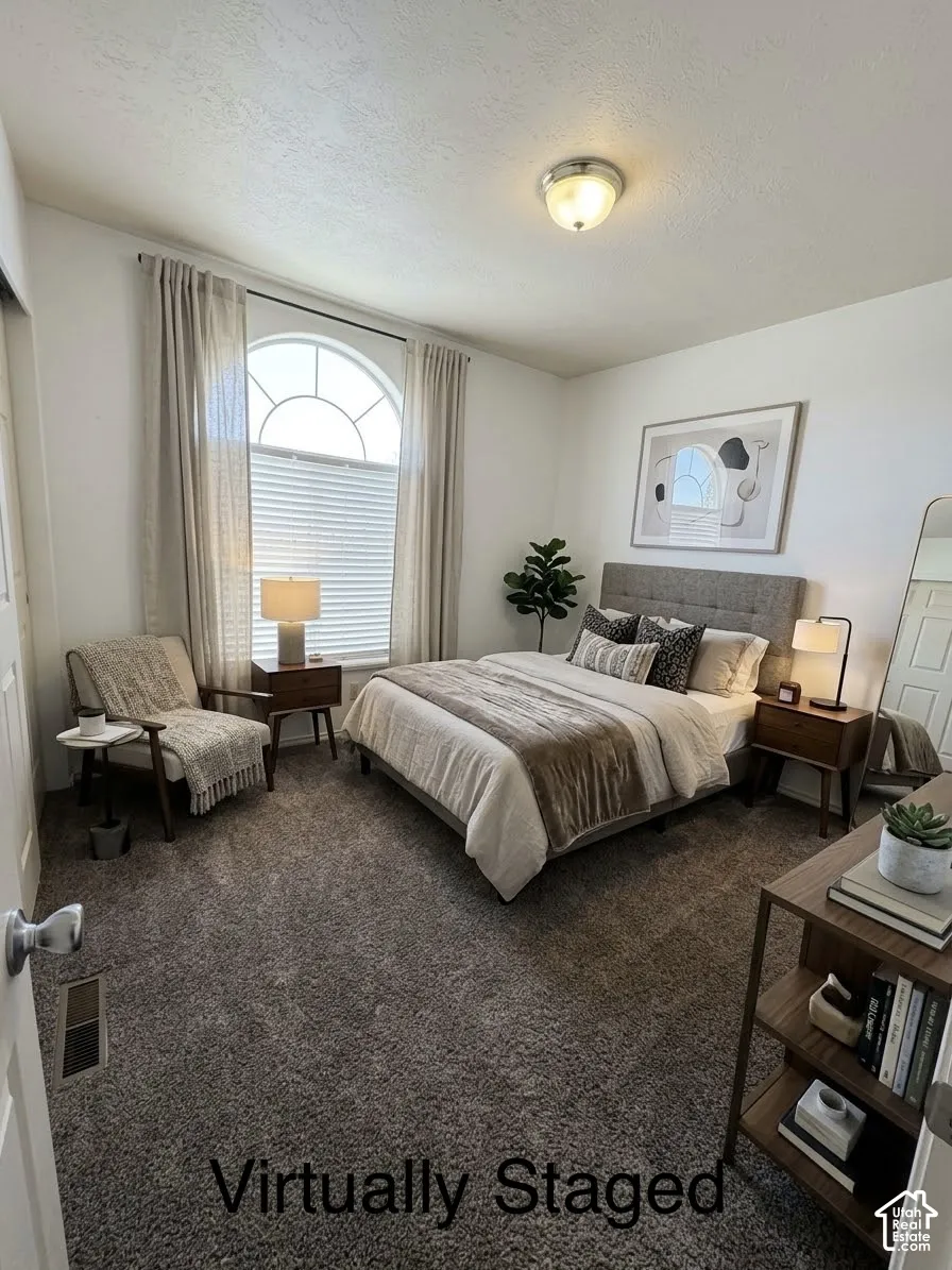 Arched window with decorative grille, neutral-toned wall-to-wall carpeting, and flush-mount ceiling lighting