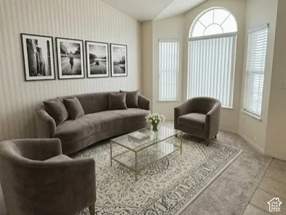 Vaulted ceiling featuring a bay window with an arched transom, vertical window blinds, and textured wall finish