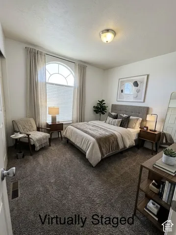 Arched window with decorative grille, neutral-toned wall-to-wall carpeting, and flush-mount ceiling lighting
