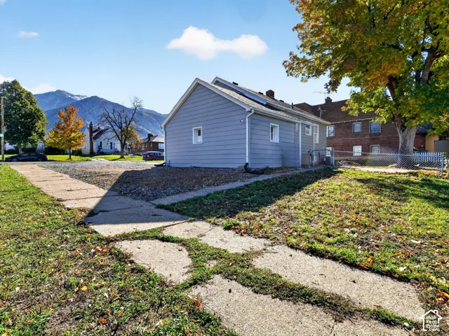 Exterior featuring gray horizontal siding, concrete paving, and mountain scenery