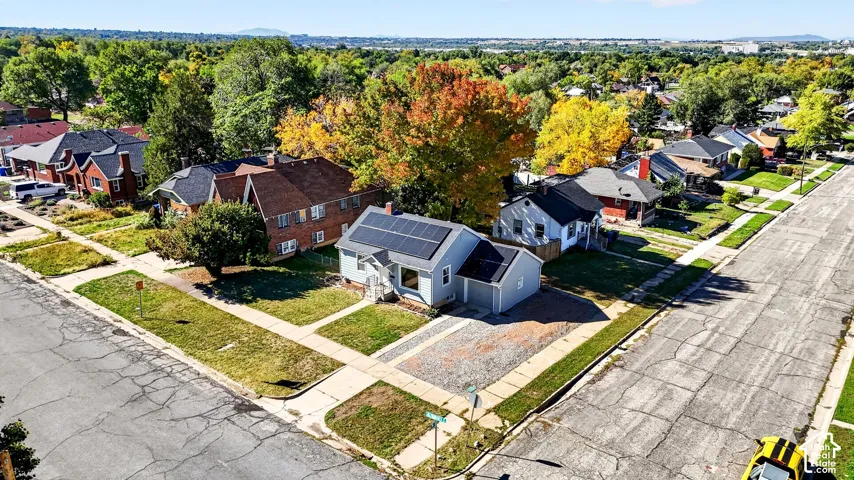 Single-story residence featuring a roof-mounted solar panel array, attached garage, and corner lot location