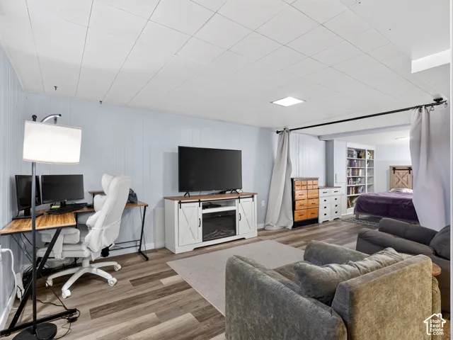 Interior space featuring wood-finish flooring, panelled walls, and built-in shelving