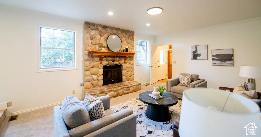 Floor-to-ceiling river rock fireplace with a built-in wooden mantel, recessed lighting, and multi-pane windows