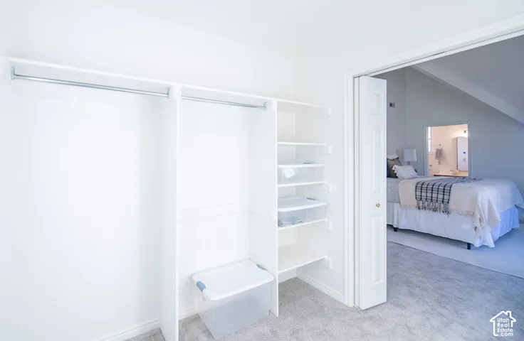 Walk-in closet featuring white built-in shelving and dual metal garment rods