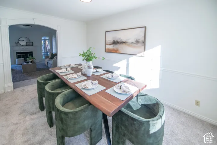 Dining area featuring an arched entryway with decorative trim and chair rail molding