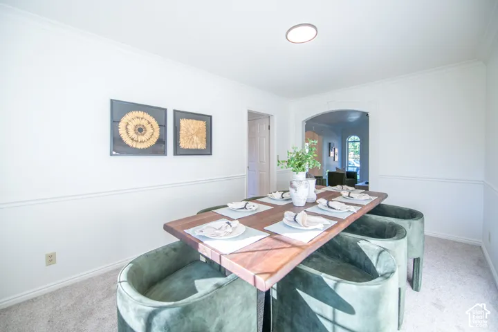 Dining area featuring chair rail molding, arched entryway, and flush-mount ceiling lighting