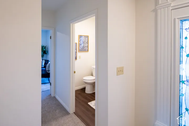Interior hallway featuring neutral wall finishes, wood-finish flooring, and a door frame with fluted casing