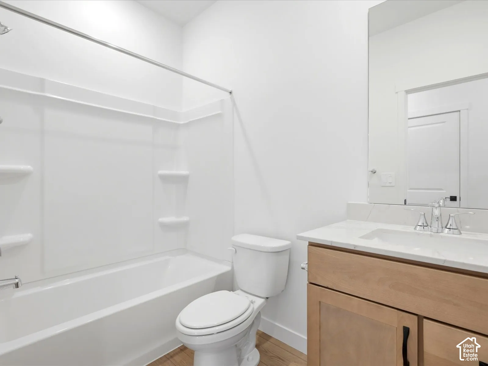 **DISCLAIMER**  Interior package may vary. Bathroom featuring a wood-finish vanity with a stone-surface countertop, an undermount sink, a chrome-finish faucet, and a combination shower and bathtub enclosure
