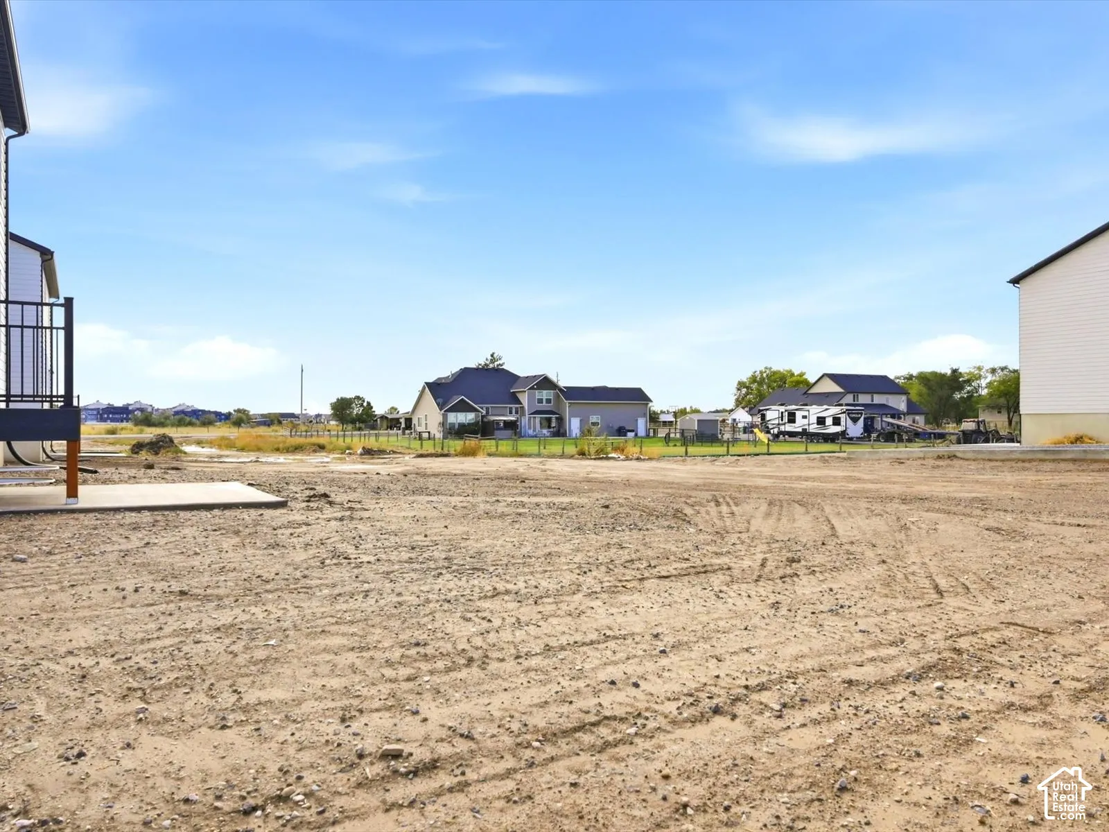 Expansive lot featuring a concrete patio and metal railings