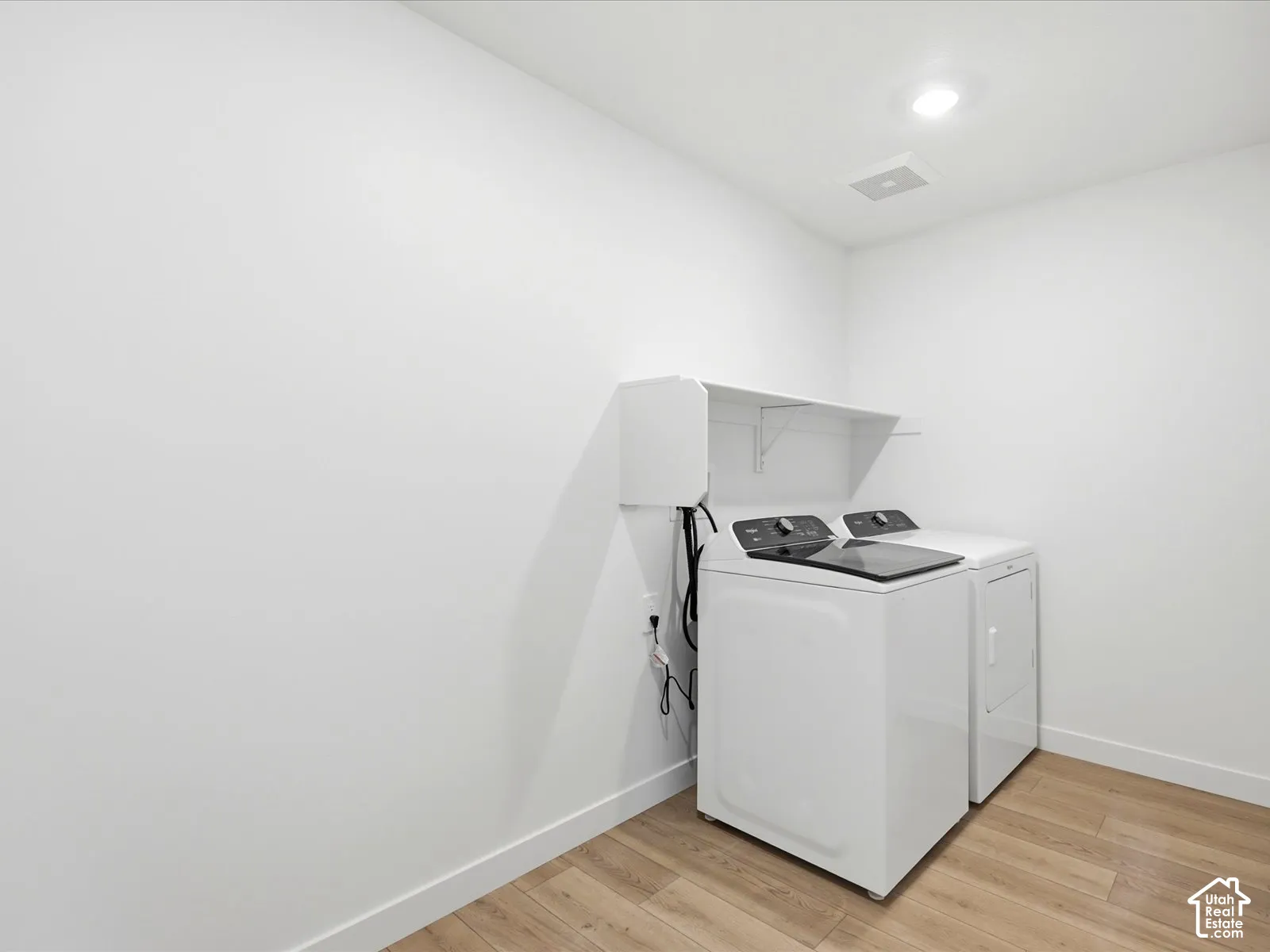 **DISCLAIMER**  Interior package may vary. Utility area featuring wood-finish flooring, recessed lighting, and wall-mounted white storage shelving