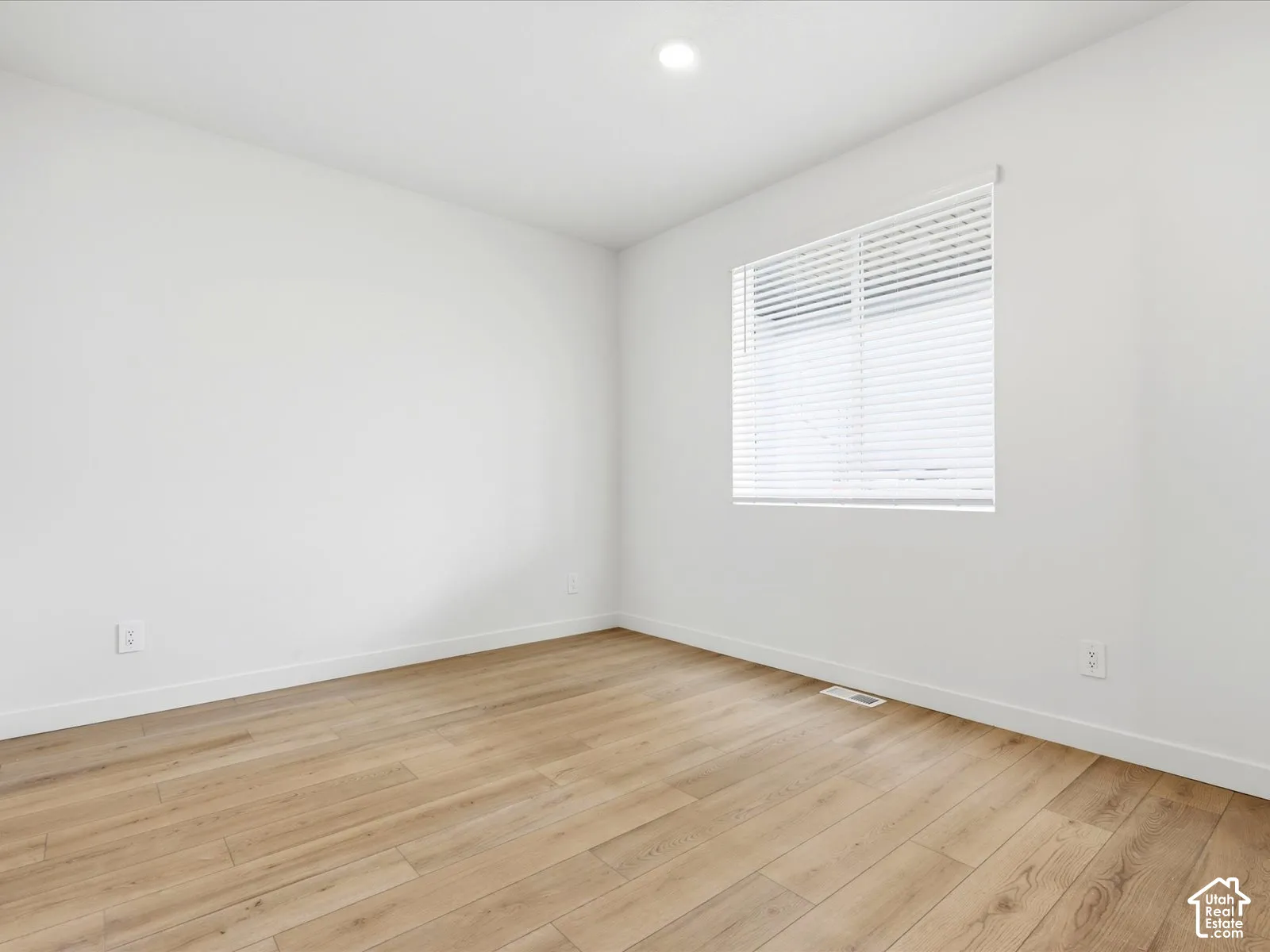 **DISCLAIMER**  Interior package may vary. Neutral-toned room featuring wood-finish flooring, recessed lighting, and a single window with horizontal blinds