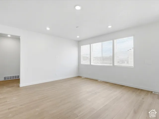 **DISCLAIMER**  Interior package may vary. Interior room featuring wood-finish flooring, recessed lighting, and expansive windows with horizontal blinds