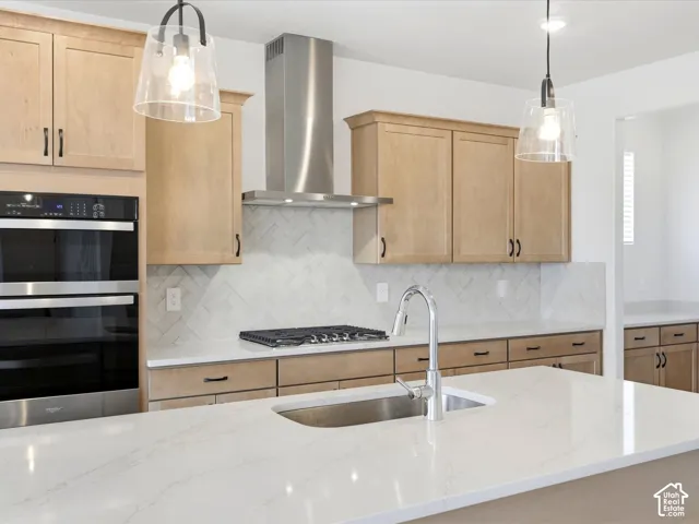 **DISCLAIMER**  Interior package may vary. Kitchen featuring light-finish cabinetry, quartz countertops, herringbone-pattern tile backsplash, stainless steel built-in double oven, and pendant lighting