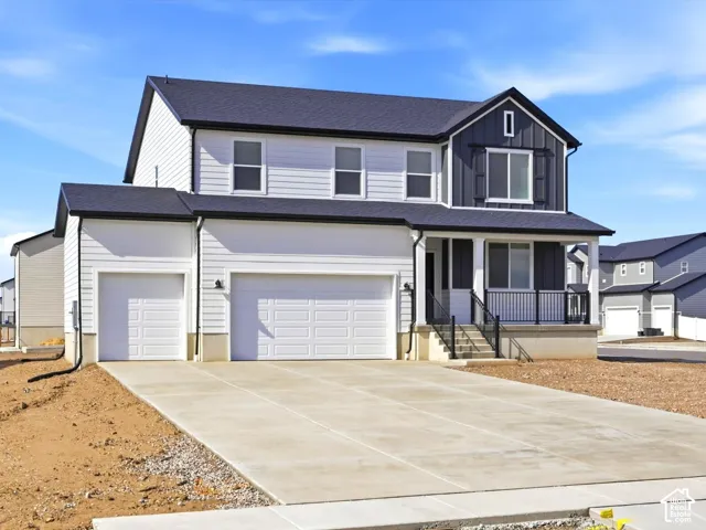 Two-story exterior featuring white horizontal siding, dark vertical board-and-batten accents, a covered front porch with a black metal railing, and a three-car garage