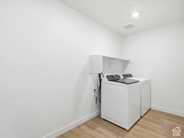 **DISCLAIMER**  Interior package may vary. Utility area featuring wood-finish flooring, recessed lighting, and wall-mounted white storage shelving