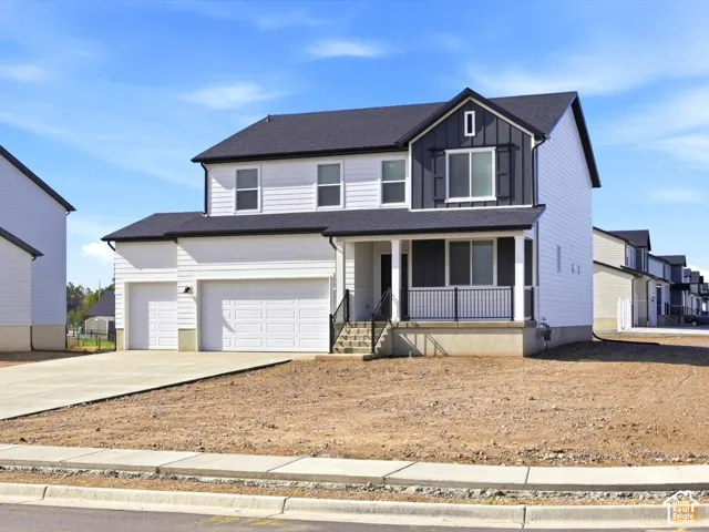 Two-story residence featuring horizontal lap siding, vertical board-and-batten accents, a covered front porch with metal railing, and a three-car attached garage