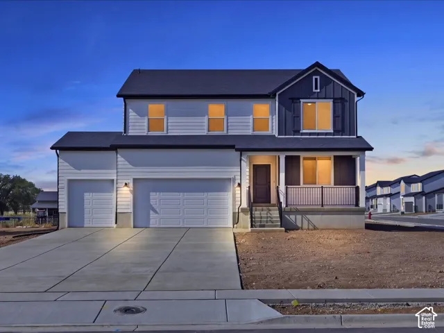 Two-story exterior featuring a mixture of horizontal siding and vertical board-and-batten, a three-car garage, and a covered front porch with metal railing