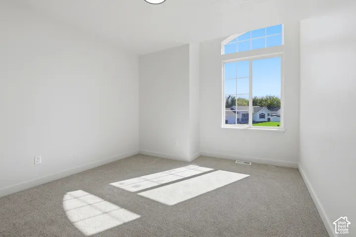 Neutral interior featuring wall-to-wall carpeting and a tall window with a semicircular transom