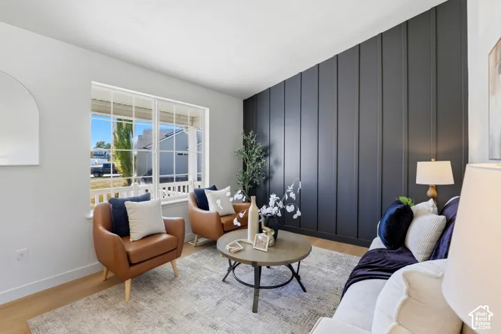 Vaulted ceiling featuring a dark-toned vertical board-and-batten accent wall and large picture window with grid detailing