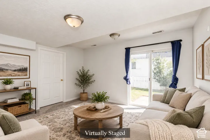 Interior room featuring neutral carpeting, sliding glass doors, and two flush-mount ceiling light fixtures