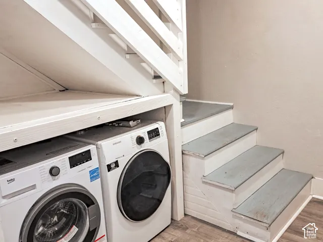 Built-in laundry alcove featuring painted wood-finish stairs and integrated under-stair shelving