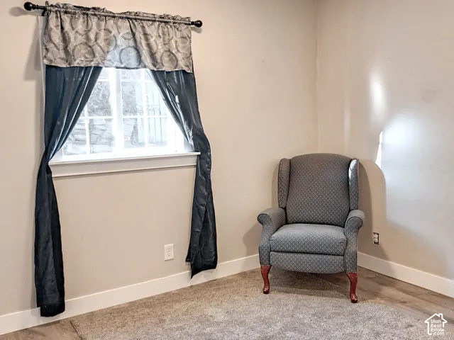 Multi-pane window with a sill, neutral wall tones, and wood-finish flooring