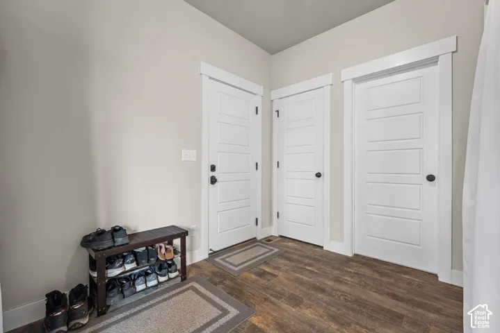 Neutral interior walls with crisp white crown molding and trim, featuring three solid-core five-panel doors with matte black hardware and wood-finish flooring