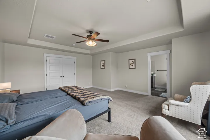 Tray ceiling with recessed lighting, central ceiling fan, and double-panel doors