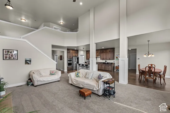 Vaulted ceilings featuring recessed lighting, dual structural pillars, wood-finish cabinetry, built-in stainless steel double ovens, and wood-finish flooring
