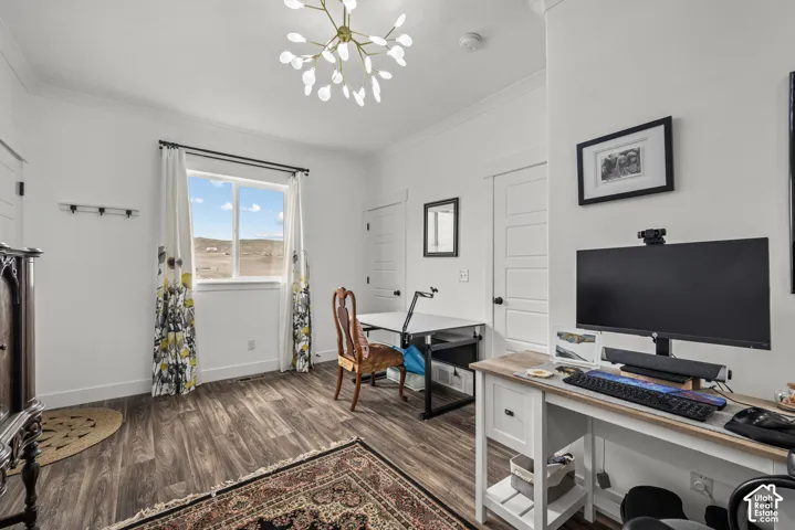 Interior room featuring wood-finish flooring, a multi-light branched chandelier, crown molding, and multi-panel doors