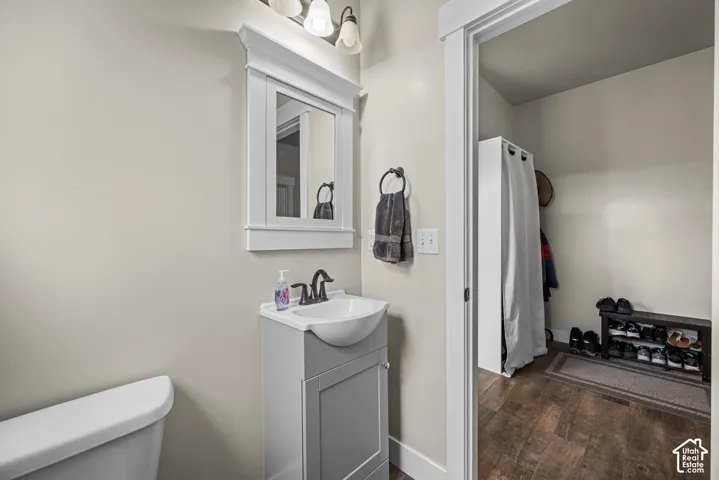 Pedestal vanity with rectangular basin, oil-rubbed bronze faucet, wall-mounted light fixture, and framed wall mirror