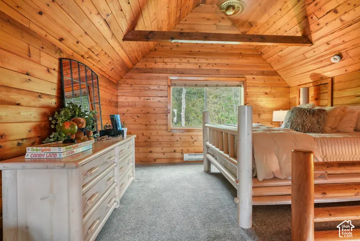 Vaulted ceiling with exposed wood beam, tongue-and-groove wood wall paneling, and a picture window