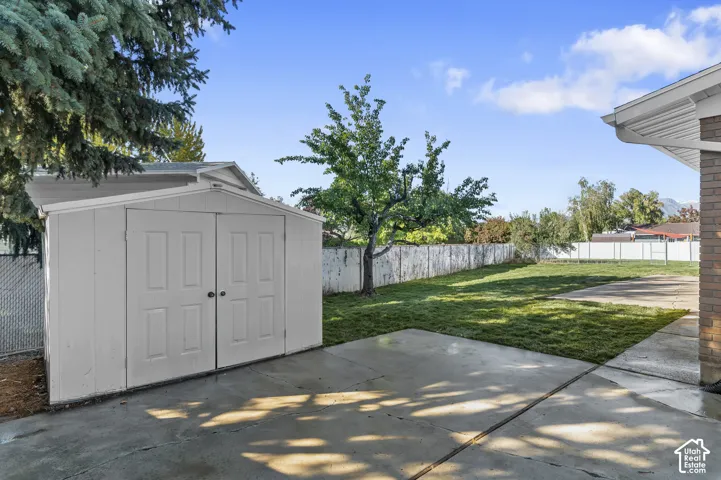 Backyard Featuring A Concrete RV Pad & Patio, Storage Shed, Manicured Lawn, With ALL NEW Sod, Sprinkler System, And Fenced In Yard