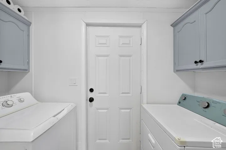 Built-in light blue cabinetry, six-panel white door with dark hardware, and white wall finishes