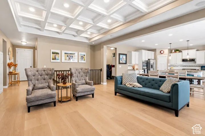 Coffered ceiling featuring recessed lighting, wood-finish flooring, and white shaker-style cabinetry with integrated stainless steel appliances