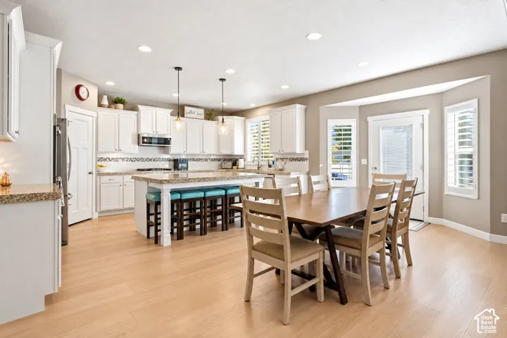 Kitchen featuring white cabinetry, stone-surface countertops, center island, recessed lighting, and wood-finish flooring